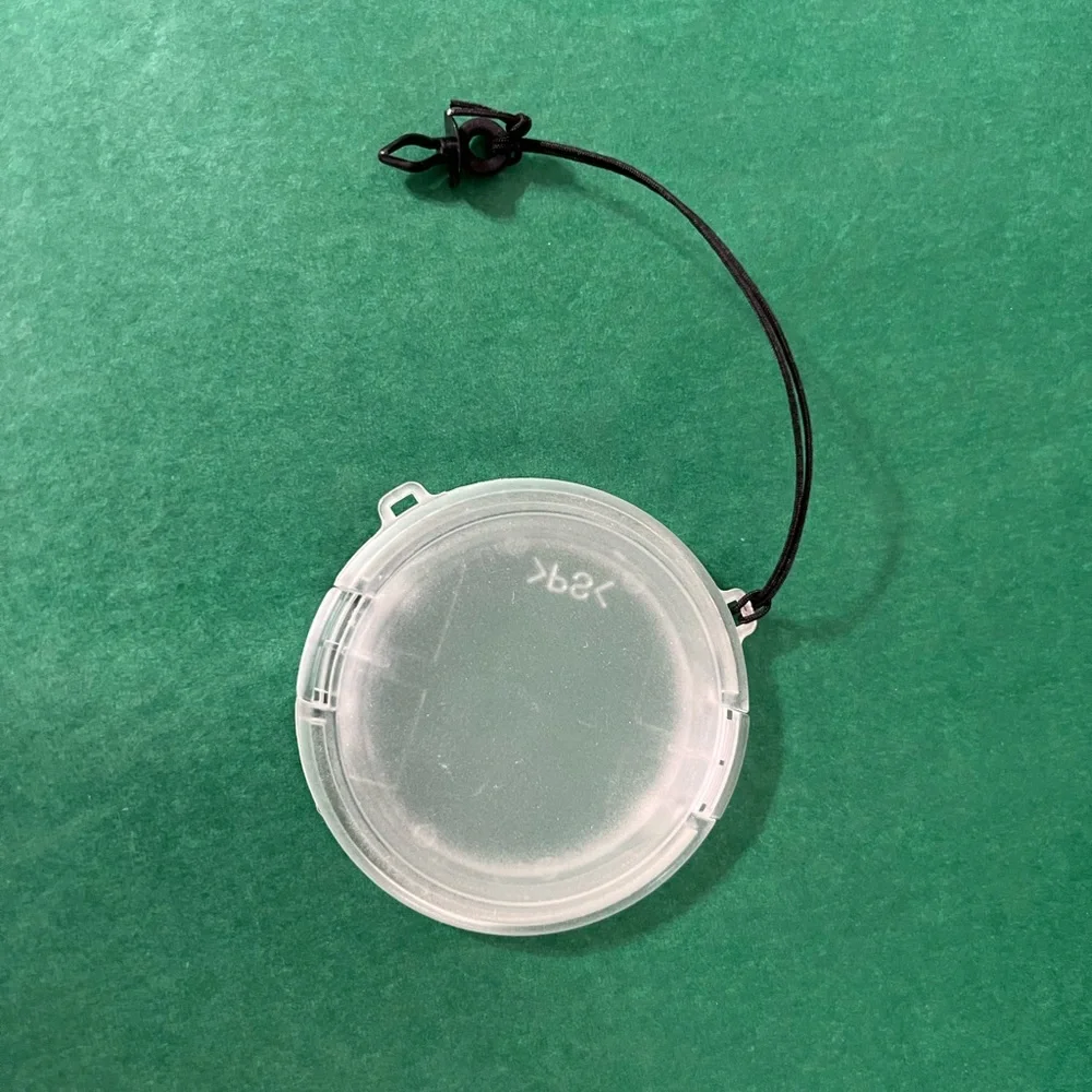 Plastic camera lens cover with string attachment